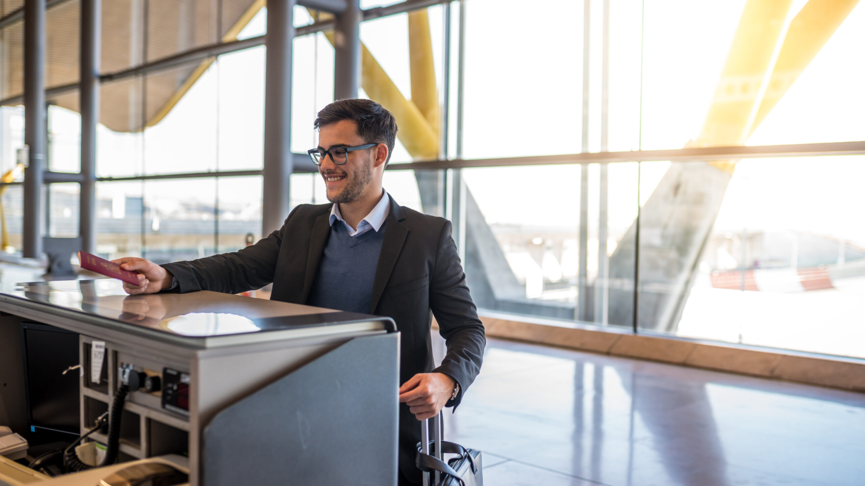 attractive young man check-in at the airport with his passport
